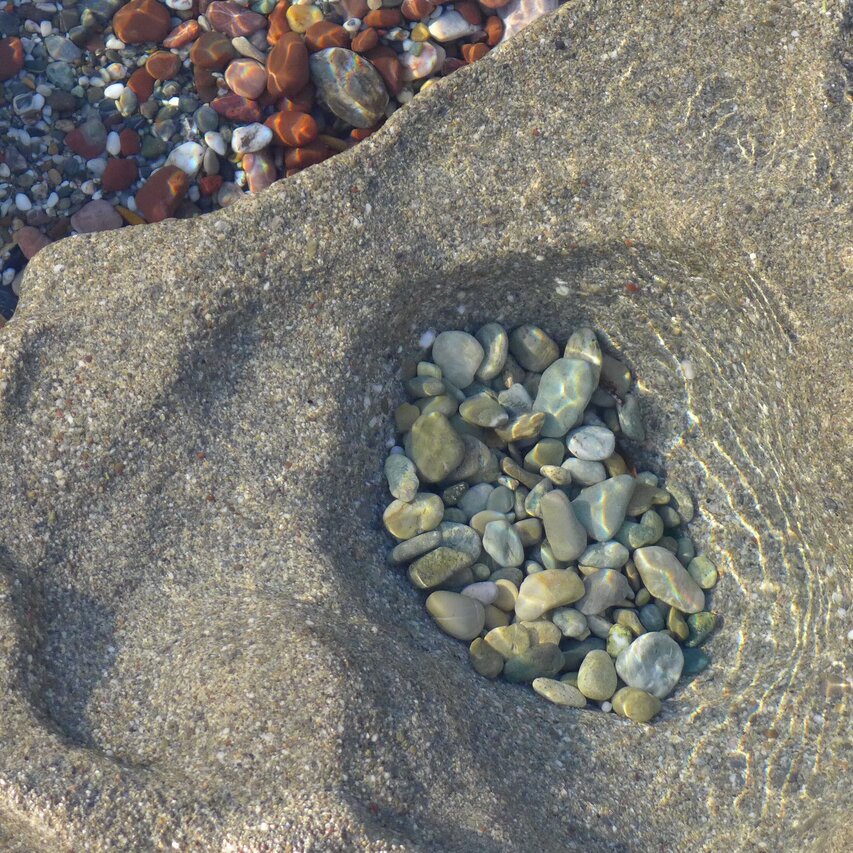 nach Farben sortierte Steine im Wasser